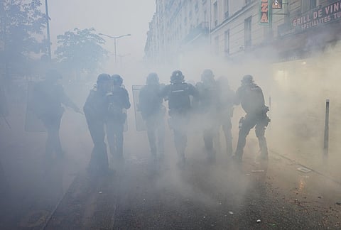 Police officers run toward protesters during a demonstration against rising living costs in Paris, Saturday, Oct. 24, 2026. 
