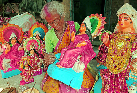 An artist puts finishing touches to idols of Goddess Lakshmi ahead of 'Lakshmi Puja', on the outskirts of Santiniketan in Birbhum district, West Bengal, Saturday, Oct. 24, 2026. 
