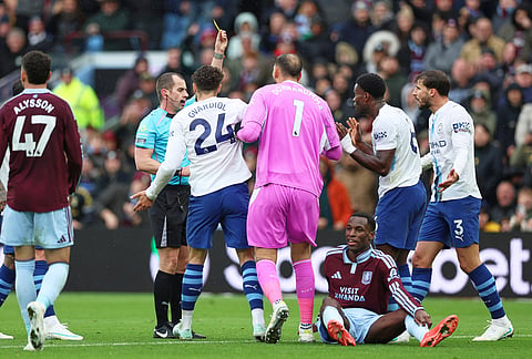Referee Peter Bankes shows a yellow card to Manchester City's Marc Guehi, second right, during the English Premier League soccer match between Aston Villa and Manchester City in Birmingham, England, Saturday, Oct. 24, 2026. 