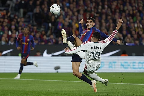 Real Madrid's Kylian Mbappe, right, attempts a shot at goal and misses in front of Barcelona's Gerard Martin, during a Spanish La Liga soccer match between FC Barcelona and Real Madrid in Barcelona, Spain, Sunday, Oct. 25, 2026.