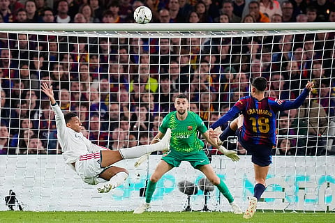 Real Madrid's Kylian Mbappe, left, attempts a shot at goal and misses in front of Barcelona's Gerard Martin, right, and Barcelona's goalkeeper Joan Garcia during a Spanish La Liga soccer match between FC Barcelona and Real Madrid in Barcelona, Spain, Sunday, Oct. 25, 2026.