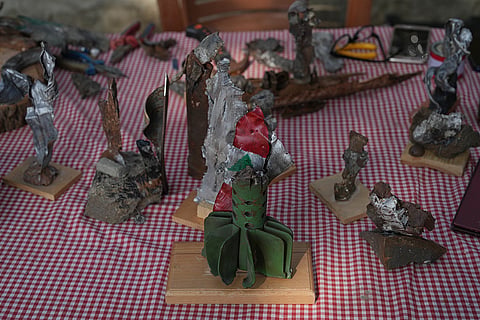 Artworks created by visual artist Lina Jouni from shrapnel collected from Israeli military munitions, including a sculpture painted with the Lebanese flag, are displayed at her home in the village of Roumin, southern Lebanon, Sunday, Oct. 25, 2026.