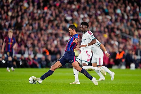 Barcelona's Rodrigo, left, is challenged by Real Madrid's Aurelien Tchouameni during a Spanish La Liga soccer match between FC Barcelona and Real Madrid in Barcelona, Spain, Sunday, Oct. 25, 2026.