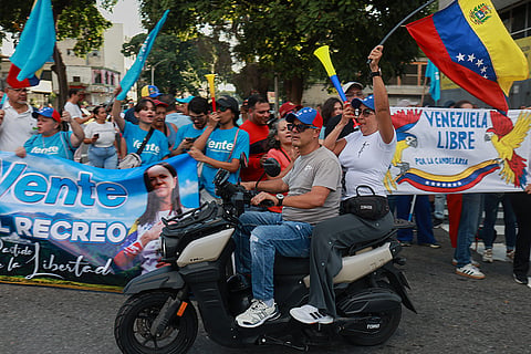 Supporters of Venezuelan opposition leader and Nobel Peace Prize laureate Maria Corina Machado rally as they await her arrival in Caracas, Venezuela, following her return to the country after months abroad, Sunday, Oct. 25, 2026.
