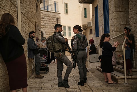 Israeli settlers and border police officers line up to vote outside a polling station during Israel's general election in Hebron, West Bank, Tuesday, Oct. 27, 2026. 
