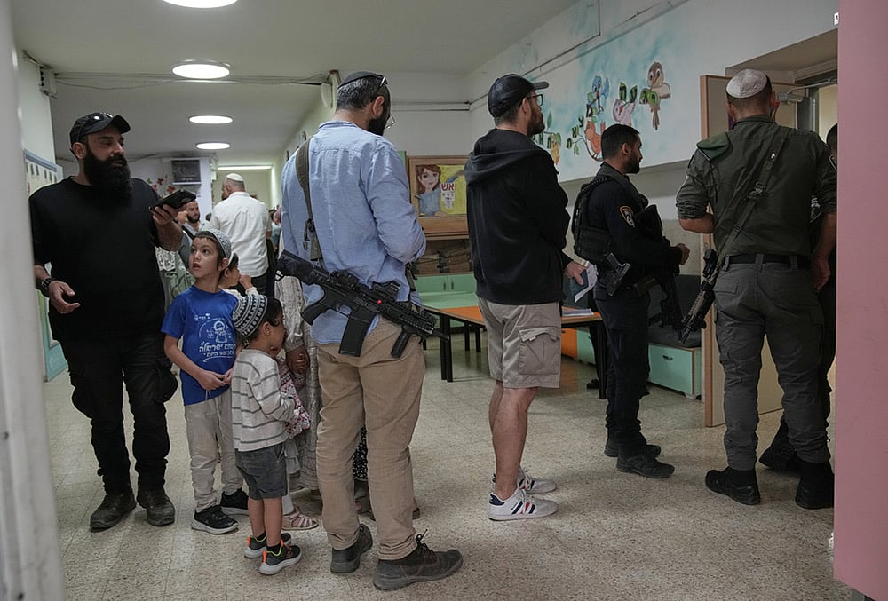 Israeli settlers line up to vote at a school 