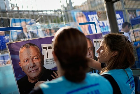 Volunteers put up a Yashar party campaign poster featuring Gadi Eisenkot outside a polling station during Israel's general election in Tel Aviv, Israel, Tuesday, Oct. 27, 2026. 