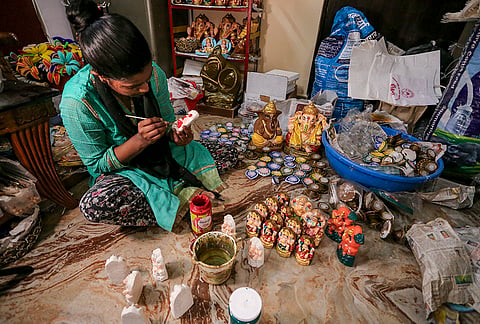 An artist prepares an idol of Lord Ganesh from cow dung ahead of Diwali festival, in Prayagraj, Sunday, Oct. 25, 2026. 