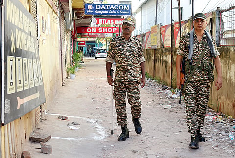 Security personnel walk past a spot marked at the site after five people were allegedly shot dead at Hotel Bilas Inn following a dispute between the owner of the property and its leaseholder on late Monday, in Guwahati, Assam.