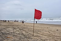 Cyclone Arnab In Photos: Coastal Areas On High Alert As Storm Approaches Andhra Pradesh | Photo: PTI : A red warning flag flutters at a deserted beach as tourists and visitors stay away ahead of the expected landfall of severe cyclonic storm 'Arnab', in Puri, Odisha, Tuesday, Oct. 27, 2026.