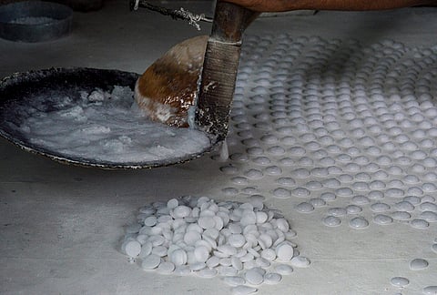 A worker makes ‘batasa’, a light, airy, and crisp traditional Indian sugar-drop sweet, for sale ahead of the ‘Diwali’ festival, in Agra, Wednesday, Oct. 21, 2026. 
