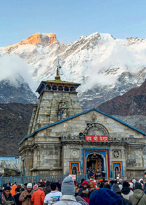 People throng the Kedarnath Dham as fresh snowfall blankets the surrounding mountains, in Rudraprayag district, Uttarakhand.