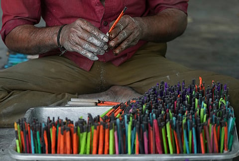 A worker makes firecrackers for the upcoming Hindu festival of Diwali at a factory on the outskirts of Ahmedabad,  Tuesday, Oct. 27, 2026. 
