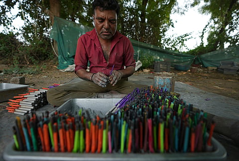 A worker makes firecrackers for the upcoming Hindu festival of Diwali at a factory on the outskirts of Ahmedabad, Tuesday, Oct. 27, 2026. 
