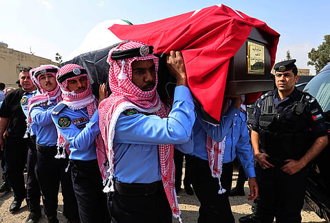 Jordanian honor guards carry a flag-draped coffin of on of the victims killed in an attack on a Greek Orthodox church during their funeral procession in Karak, Jordan, Sunday, Oct. 25, 2026. 