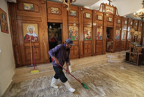 A worker scrubs the floor of St. George's Greek Orthodox Church a day after gunmen opened fire during a funeral in the village of Hamoud, in Jordan's Karak governorate, Saturday, Oct. 24, 2026. 
