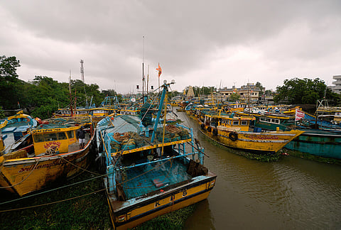 A fisherman checks boats anchored in coastal backwaters at Kakinada, as Cyclone Arnab crossed the Andhra Pradesh coast in the early hours of Wednesday, Oct. 28, 2026. 