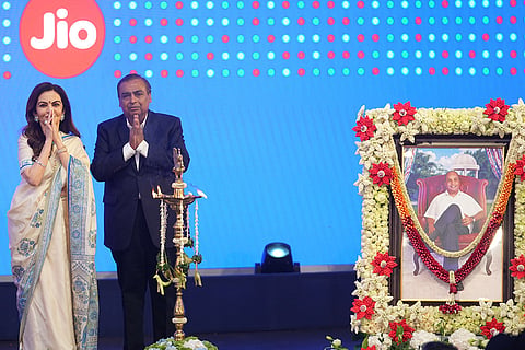 Mukesh Ambani, right, chairman and managing director of Reliance Industries, and his wife, Nita Ambani, greet attendees beside a portrait of his father, Dhirubhai Ambani, at the initial public offering (IPO) listing ceremony of Reliance Industries' Jio Platforms at the National Stock Exchange (NSE) in Mumbai, India, Wednesday, Oct. 28, 2026.
