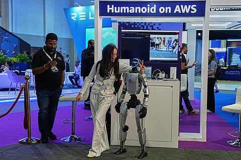 A woman poses beside a humanoid robot at the Dubai AI Festival in Dubai, United Arab Emirates, Tuesday, Oct. 27, 2026.