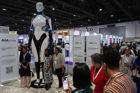Visitors pose beside a humanoid robot on display at the AIA Orbis stand at the Dubai AI Festival in Dubai, United Arab Emirates, Tuesday, Oct. 27, 2026.