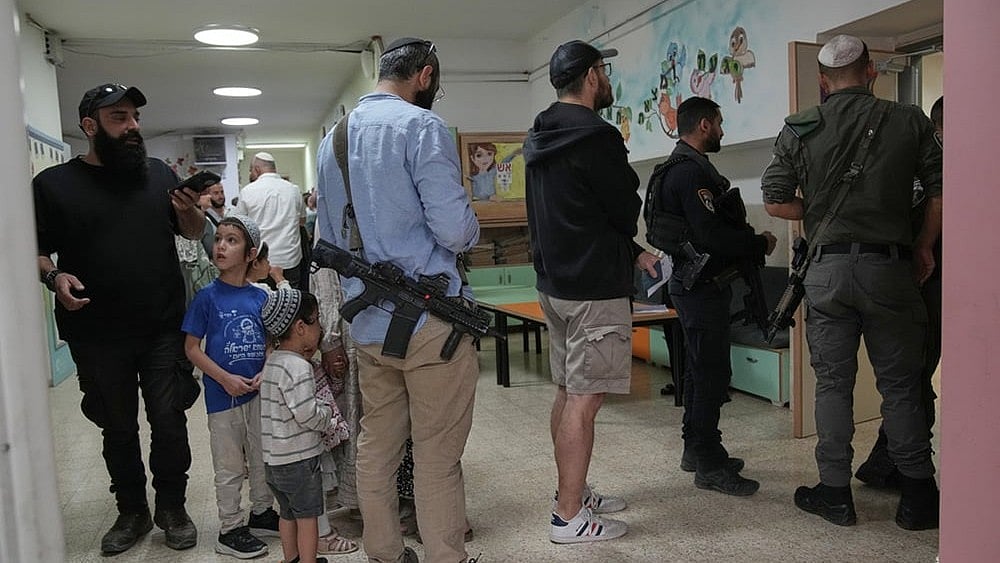 | Photo: AP/Leo Correa : Israeli settlers line up to vote at a school serving as a polling station during Israels general election in the settlement of Kiryat Arba, in the occupied West Bank, Tuesday, Oct. 27, 2026. 