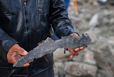 A man holds a piece of debris at the site of a Jordanian airstrike in Al-Tuff, in the countryside of Daraa province in southern Syria, Tuesday, Oct. 27, 2026. 