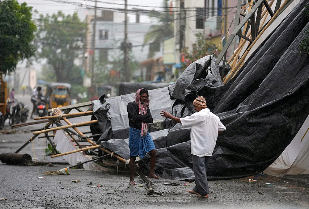 A man walks past the destruction caused at Kakinada, after Cyclone Arnab crossed the Andhra Pradesh coast in the early hours of Wednesday, Oct. 28, 2026.  - | Photo: AP/Mahesh Kumar A.