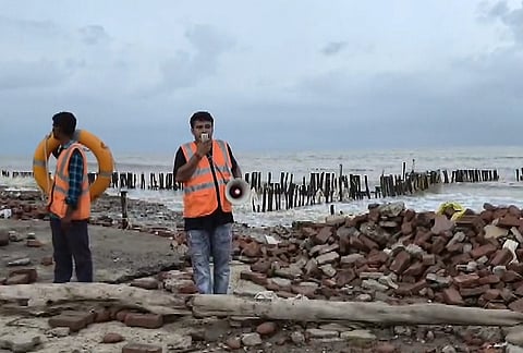Officials make announcements as they keep a vigil on a beach amid rain and strong winds triggered by Cyclone Arnab, in South 24 Parganas, West Bengal.