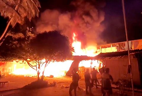People gather at the site as flames and thick plumes of smoke billow after a fire broke out at a market in Goa’s port town of Vasco, gutting more than 150 shops, in South Goa district. 