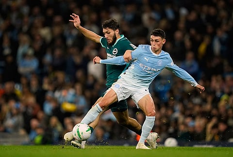 Brighton's Jaouen Hadjam, left, challenges for the ball with Manchester City's Phil Foden during the English League Cup soccer match between Manchester City and Brighton and Hove Albion in Manchester, England, Wednesday, Oct. 28, 2026. 
