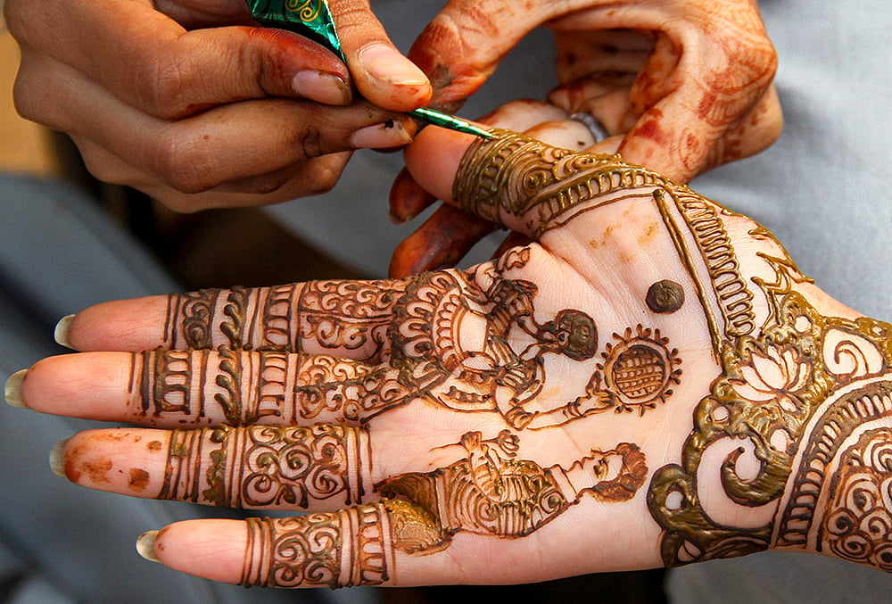 | Photo: PTI : A woman gets henna designs applied ahead of the Karva Chauth festival, in Gurugram, Haryana, Tuesday, Oct. 27, 2026. 