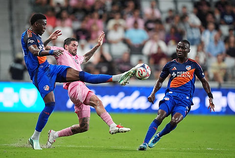 FC Cincinnati defender Teenage Hadebe, left, controls the ball past Inter Miami midfielder Rodrigo de Paul as FC Cincinnati midfielder Obinna Nwobodo looks on during the second half of an MLS soccer match as , Wednesday, Oct. 28, 2026, in Miami.