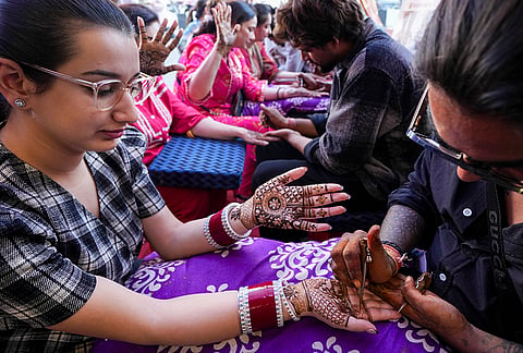 Women being applied henna on their hands ahead of 'Karva Chauth' festival, in Amritsar, Punjab, Wednesday, Oct. 28, 2026. 