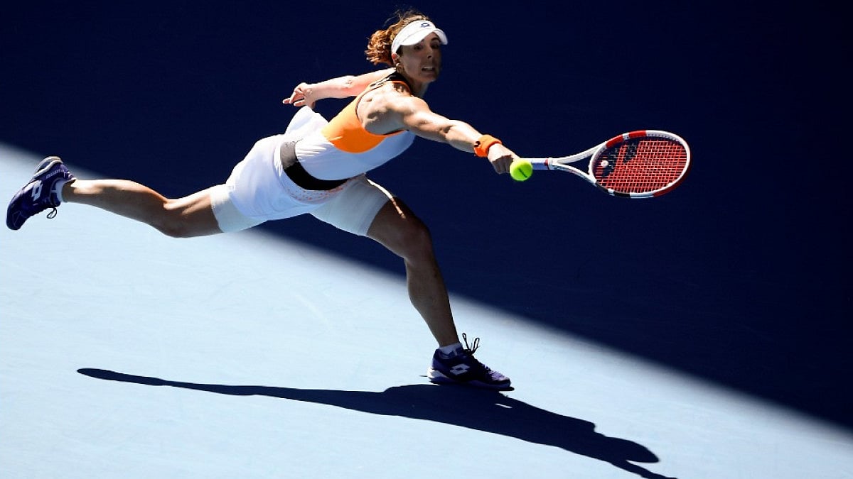 France's Alize Cornet makes a backhand return to Simona Halep at Australian Open 2022.
