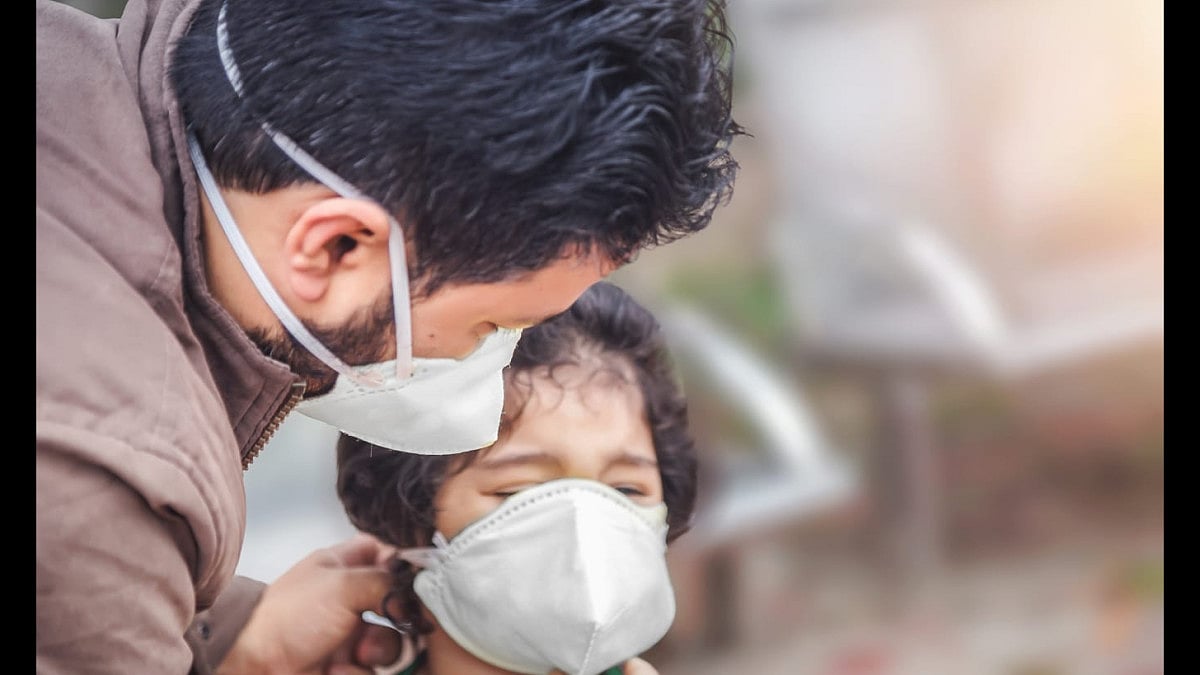 A father putting a mask on his child