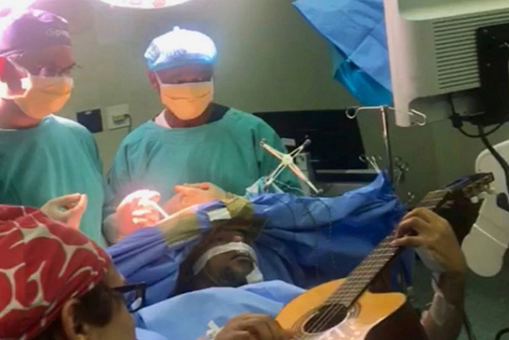 Jazz musician playing guitar during his surgery