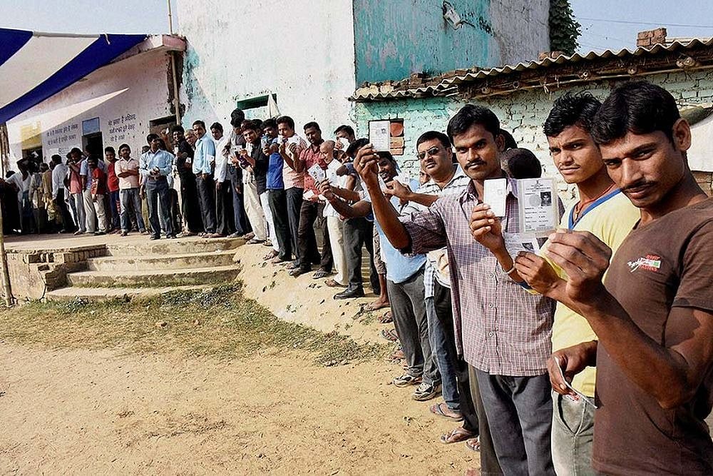 Voters holding Voter ID Cards outside a polling station in Bihar