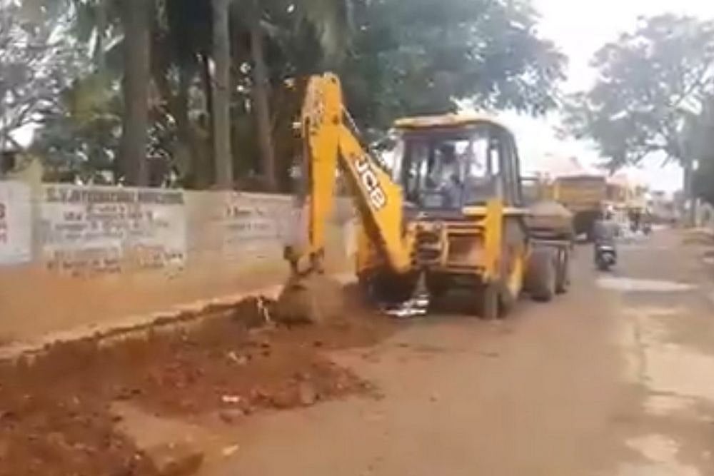 A JCB truck filling potholes with mud and other material in Bengaluru. 