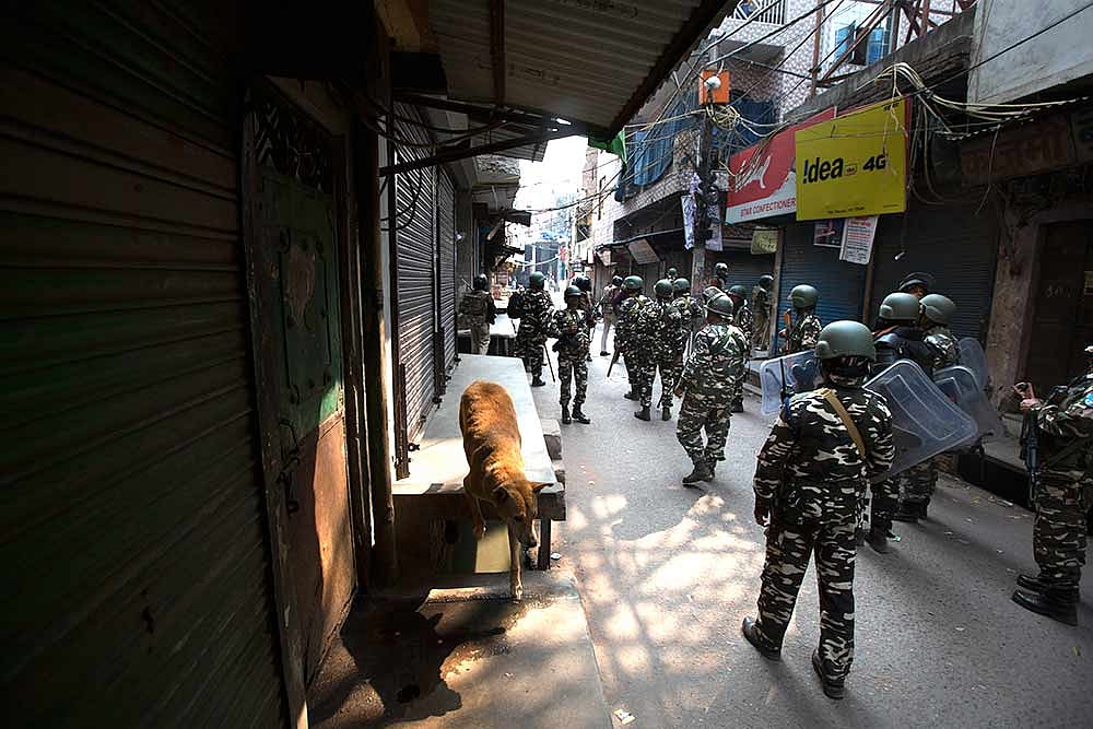 Paramilitary force soldiers take out a flag march in a senstitive area that saw violence on Tuesday, in New Delhi.