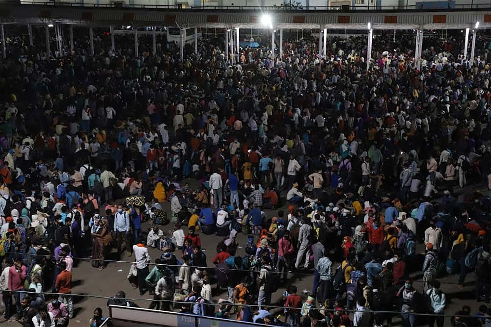 Migrants wait to board a bus to their native villages during a nationwide lockdown, imposed in the wake of coronavirus pandemic at Kaushambi, in Ghaziabad.