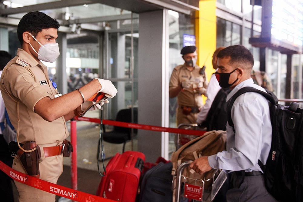 Security personnel and passengers wear masks as preventive against coronavirus, at NSCBI Airport, in Kolkata.