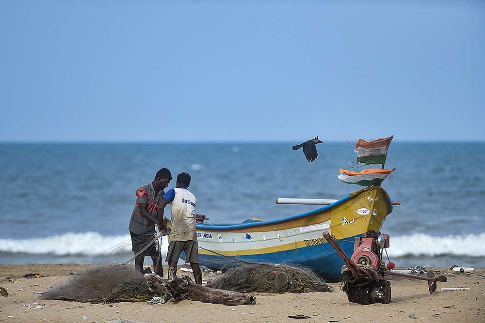 Fishermen arrange their net ar Marina beach, during Unlock 2.0, in Chennai.