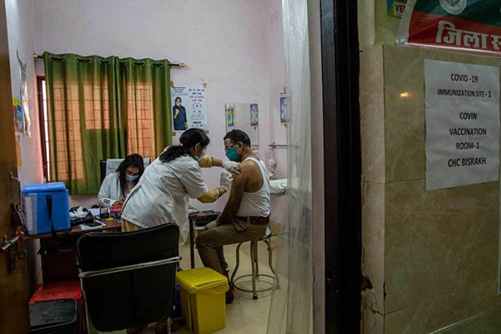 A health worker administers COVID-19 vaccine to a police officer at a health centre in Greater Noida, a suburb of New Delhi.