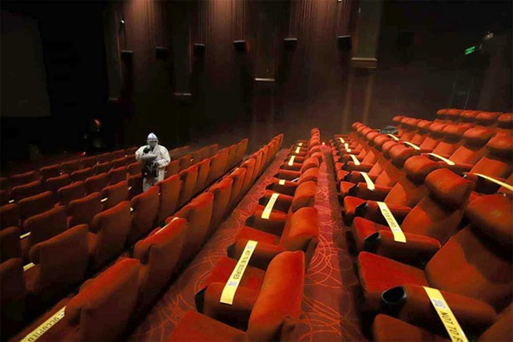 A PVR Cinemas employee sprays disinfectants on the seats of a cinema hall in New Delhi.
