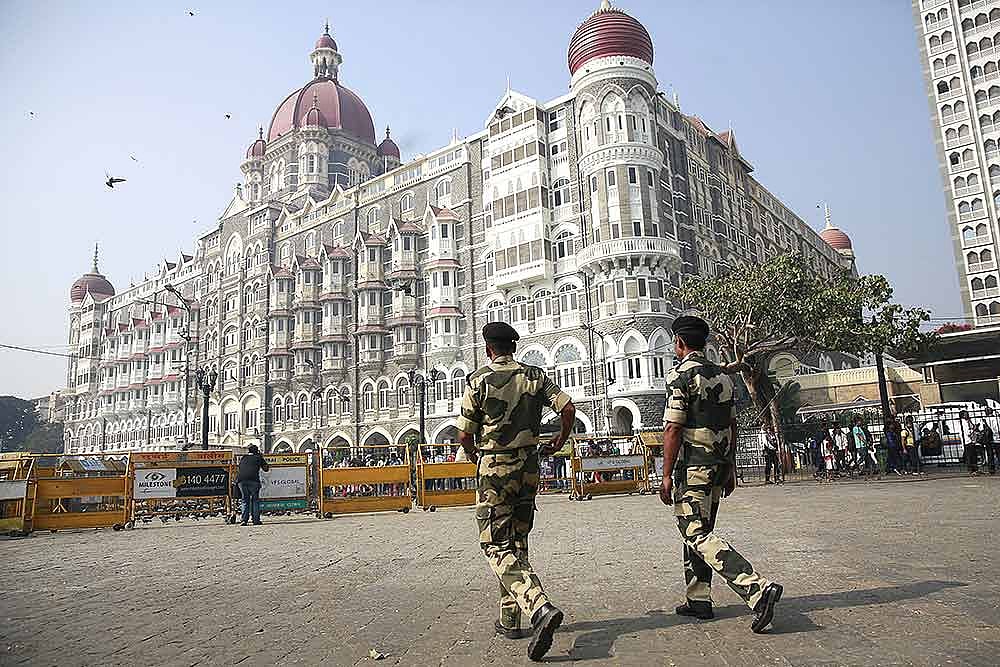 Police officers walk outside the Taj Mahal Hotel, one of the sites of the Mumbai terror attacks