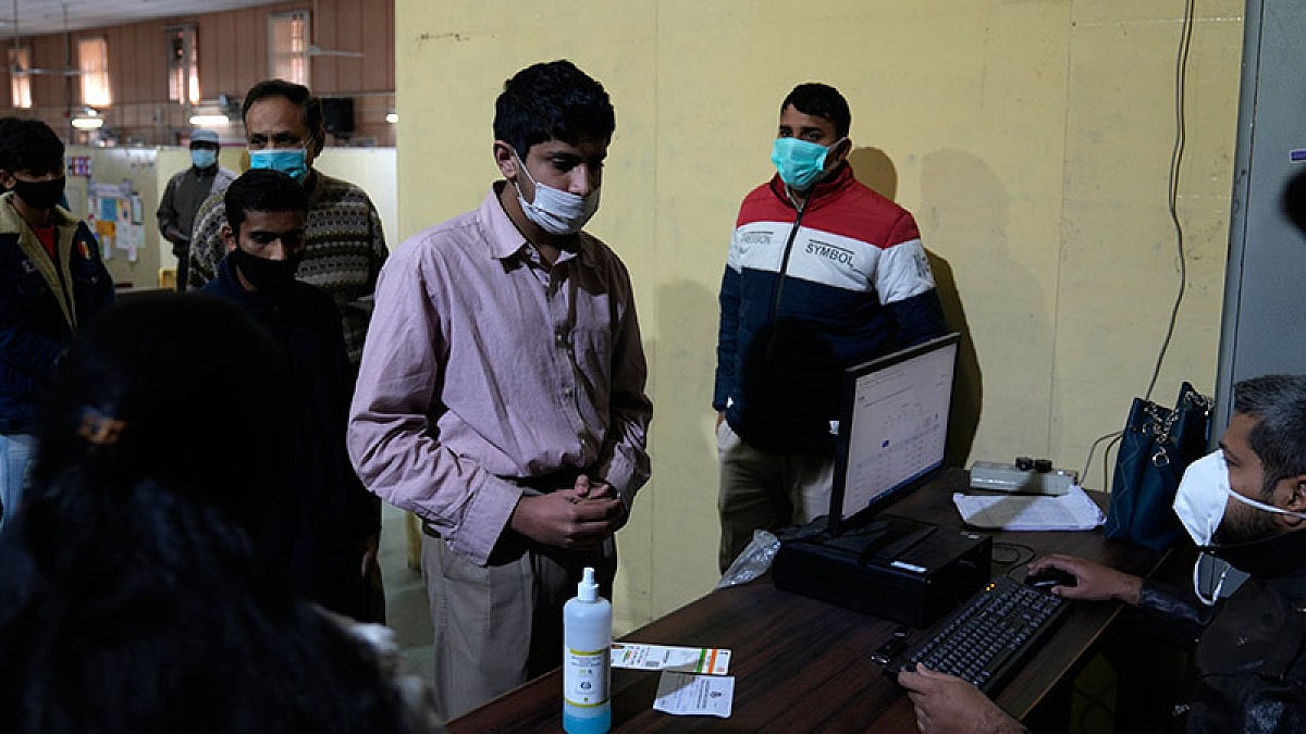 People wait in a queue to register for a Covid-19 vaccination at a makeshift center.