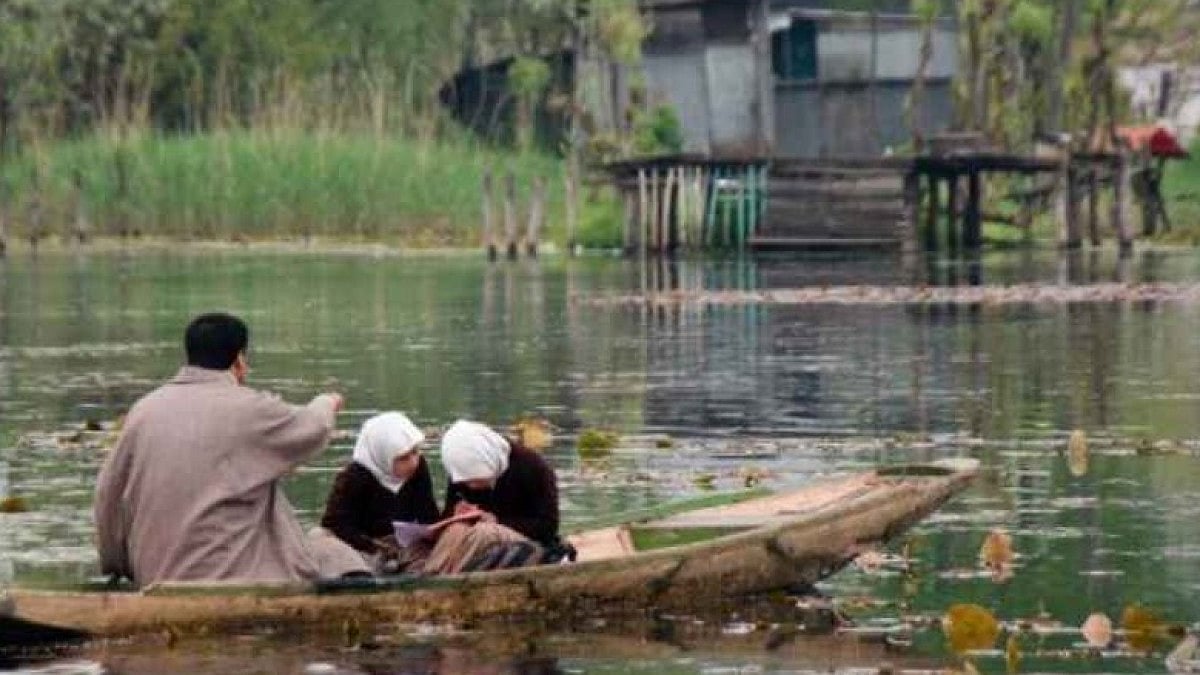 Kashmiri students studying on a boat
