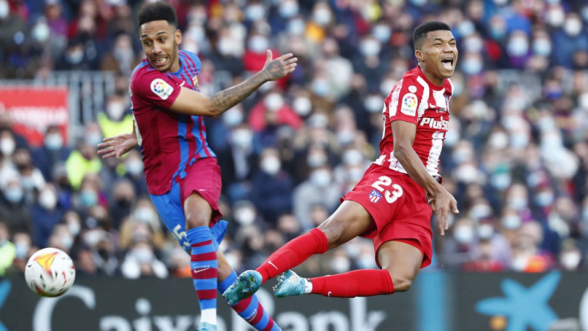 Atletico Madrid's Reinildo Mandava, right, is challenged by Barcelona's Pierre-Emerick Aubameyang.
