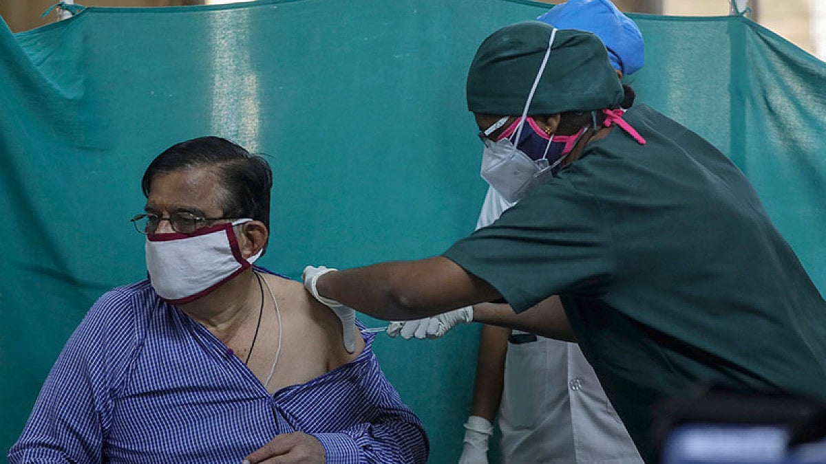 A health worker administers the third dose of Covishield COVID-19 vaccine to an elderly person.
