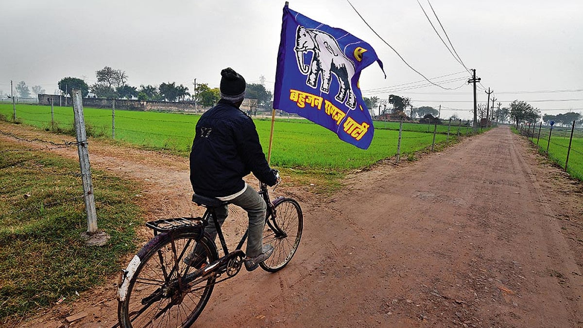 A man riding a cycle with a BSP flag in Uttar Pradesh. 